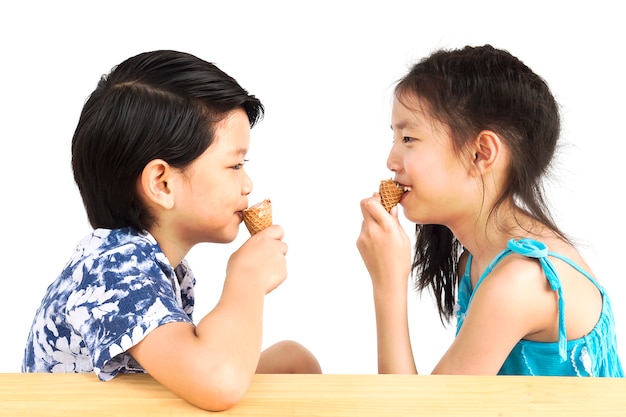 アジアの子供たちはアイスクリームを食べています