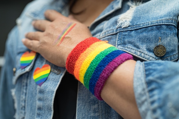 Lgbtプライド月間のレインボーフラッグリストバンドのシンボルを身に着けているアジアの女性は、ゲイレズビアンバイセクシュアルトランスジェンダー人権の6月の社会の毎年恒例を祝います Premium写真