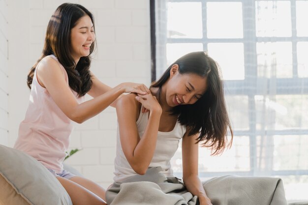 アジアのレズビアンlgbtq女性カップルは自宅でお互いをマッサージします。