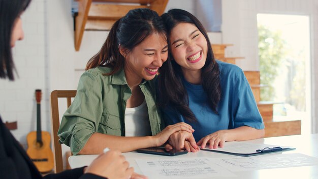 Asian Lesbian lgbtq women couple sign contract at home