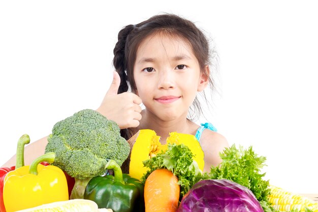 アジアの素敵な女の子を示す新鮮なカラフルな野菜の表現を楽しむ