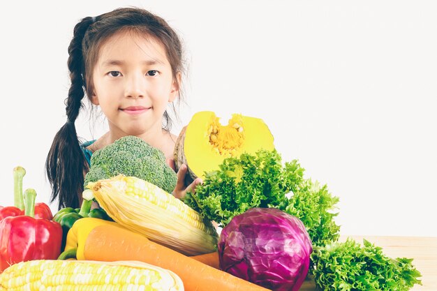 Азиатский симпатичный показ девушки наслаждается выражением со свежими красочными овощами