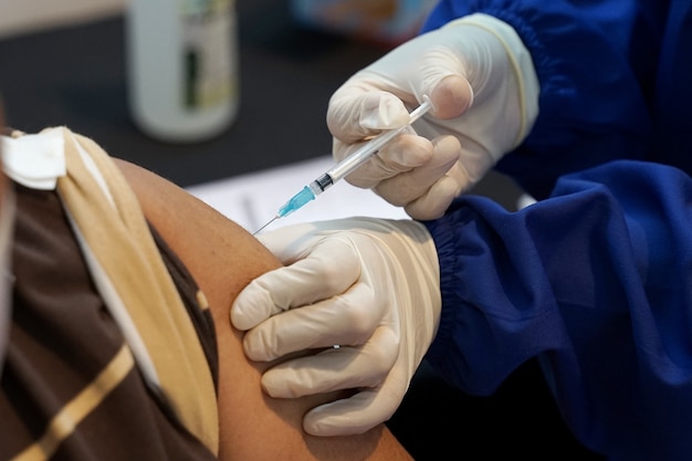 Мужчина из азии получает вакцину sinovac против коронавируса, получающего вакцину covid