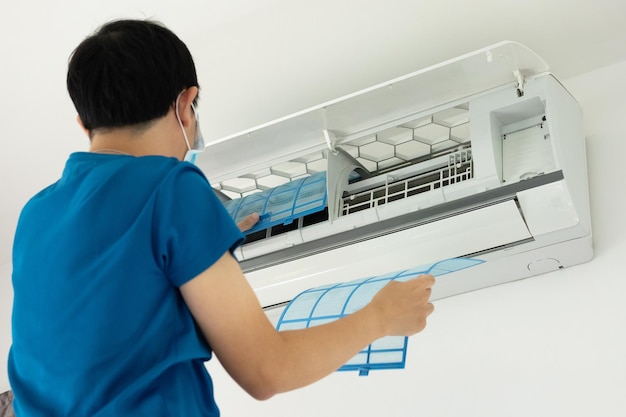Asian man cleaning air conditioner filter