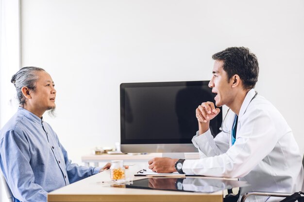 Служба доктора азиатского мужчины помогает поддерживать обсуждение и консультирование, беседу с пациентом пожилого возраста из азии на встрече с концепцией выраженного доверия в области здравоохранения в больнице. здравоохранение и медицина