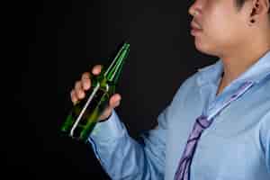 Бесплатное фото Азиатский мужчина пьет бутылку пива