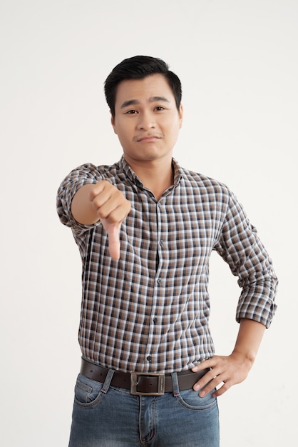 격자 무늬 셔츠와 청바지 아래로 자신의 손가락으로 스튜디오에 서 아시아 남자