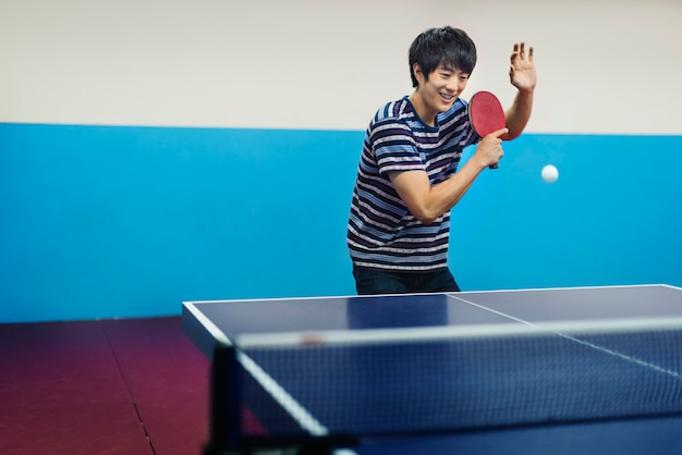 Free photo asian man playing table tennis