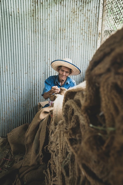 Free photo asian man sewing bags in thailand