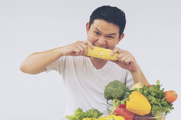 アジア人の男性が新鮮なカラフルな野菜の表情を楽しむ