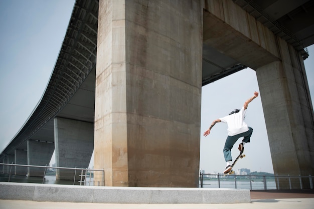 Азиатский мужчина катается на скейтборде в городе на открытом воздухе