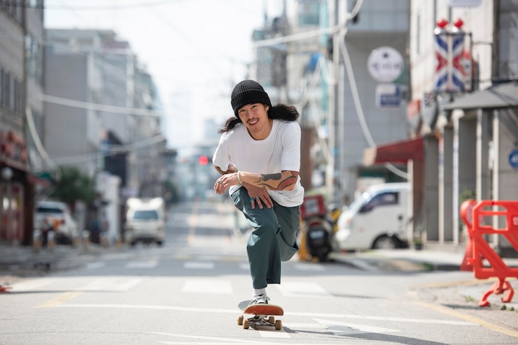 無料Photo 屋外でスケートボードをするアジア人男性