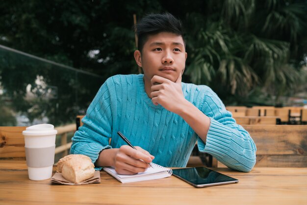 커피 숍에서 공부하는 아시아 남자.