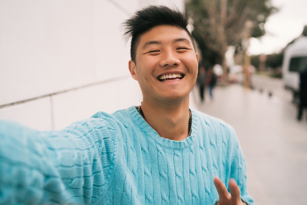 Asian man taking a selfie.