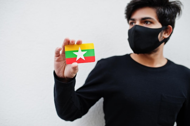 Asian man wear all black with face mask hold Myanmar flag in hand isolated on white background Coronavirus country concept