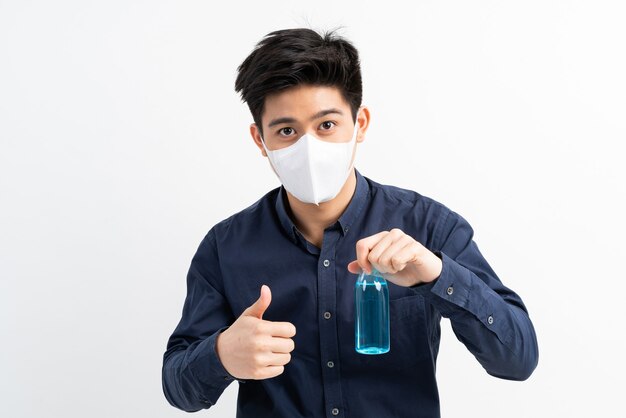 Asian man wearing Face Mask holding Alcohol for washing hands to protect Coronavirus covid-19 in quarantine room 