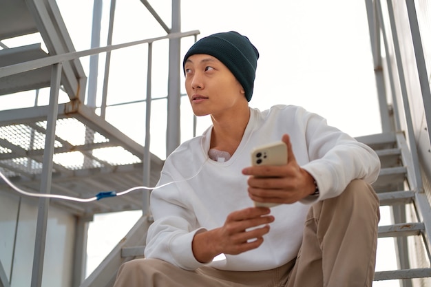 Free photo asian man with cancer outdoors low angle