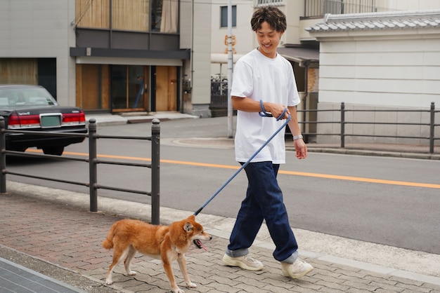 Asian man with his shiba inu dog outdoors