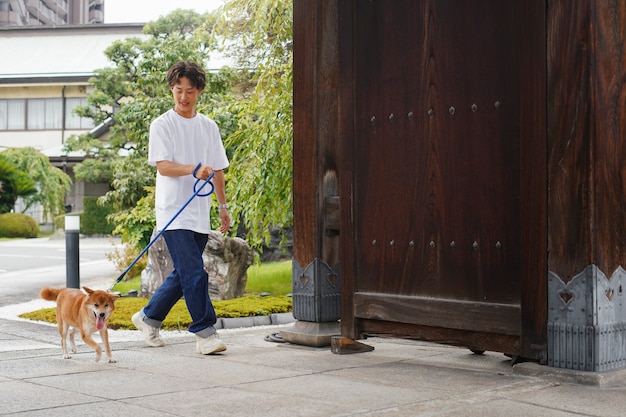 Asian man with his shiba inu dog outdoors