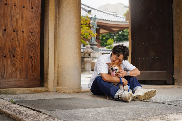 Free photo asian man with his shiba inu dog outdoors