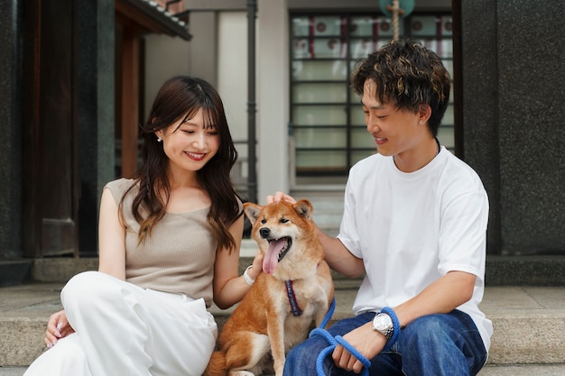 Free photo asian man and woman with their shiba inu dog outdoors