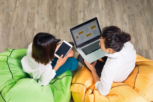 Free photo asian man and woman working on laptop and tablet