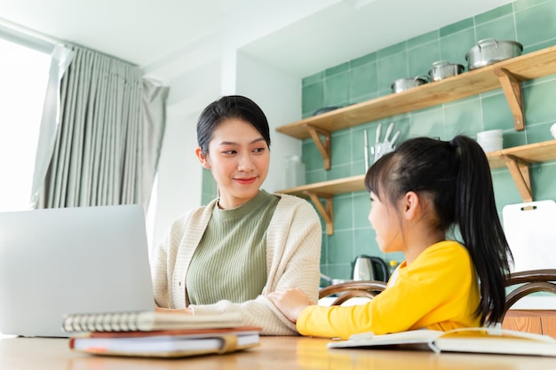 Asian mother and daughter studying together at home