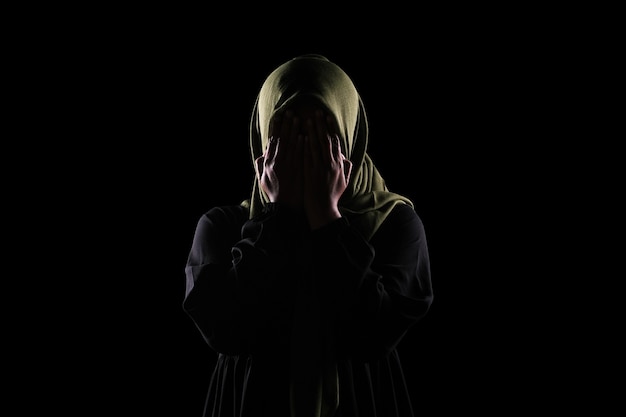 アジア​の​イスラム​教徒​の​女性​は​彼女​の​手​で​彼女​の​顔​を​覆い​、​女性​の​概念​に対する​暴力​を​停止します​。
