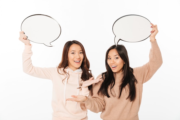 Asian positive ladies sisters holding speech bubbles.