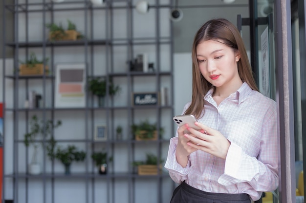 アジア​の​プロ​の​働く​女性​は​、​スマート​フォン​を​使用して​デジタル化​の​誰か​と​チャット​し​、​自宅​の​コンセプト​から​仕事​を​しています​。