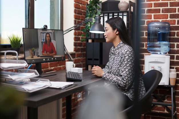 Free Photo asian research analyst on online remote videocall conference with organization leader talking about management plan. startup project manager conversating online with investor about marketing strategy.