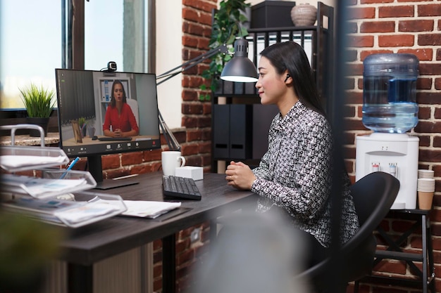 Asian research analyst on online remote videocall conference with organization leader talking about management plan. Startup project manager conversating online with investor about marketing strategy.