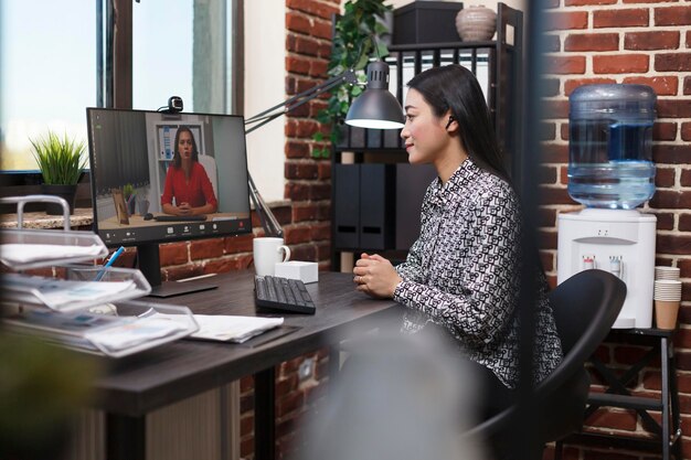 Asian research analyst on online remote videocall conference with organization leader talking about management plan. Startup project manager conversating online with investor about marketing strategy.