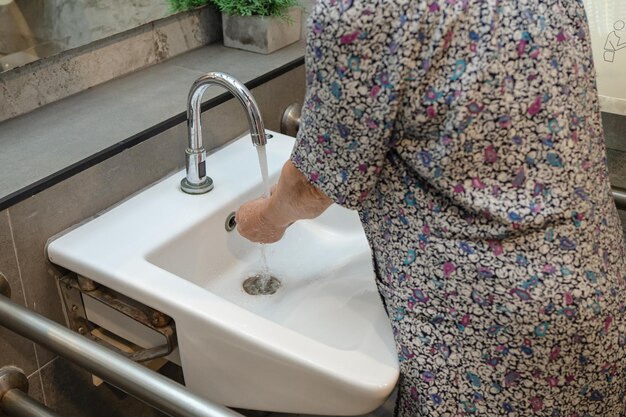 安全​感染​を​保護し​、​新しい​コロナ​ウイルス​covid​-​19​ウイルス​、​細菌​、​細菌​を​殺す​ために​石鹸​と​きれいな​水​で​手​を​洗う​アジア​の​高齢者​または​高齢​の​老​婦人​女性​患者​。