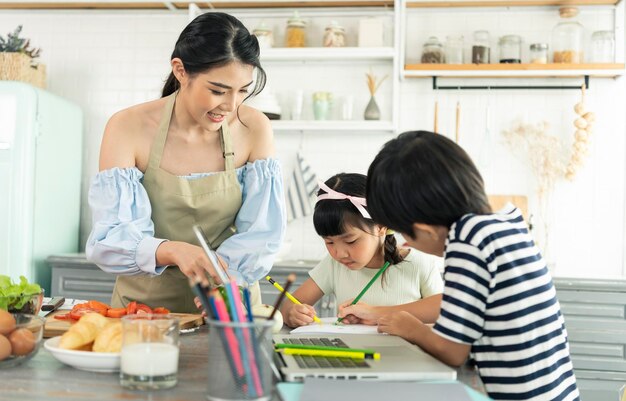 Asian single mother making food while taking care child in kitchen home school and single mother