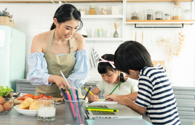 キッチンホームスクールで子育てしながら食事を作るアジア人シングルマザーとシングルマザー