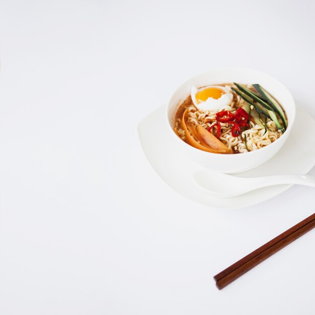Asian soup and chopsticks on white