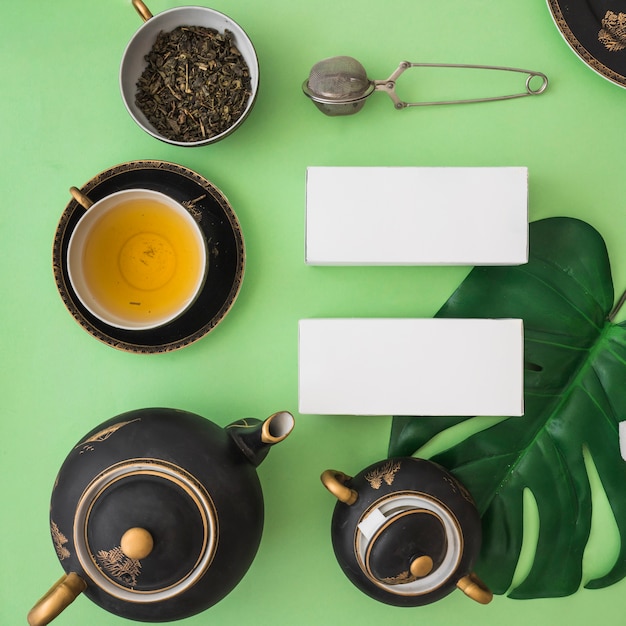 Asian tea set with herbal boxes on green backdrop