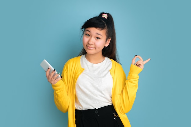 Free photo asian teenager's portrait isolated on blue  space