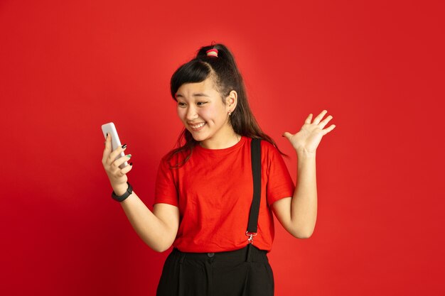 Портрет азиатского подростка изолирован на красном пространстве