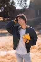 Free photo asian teenager standing with book in park