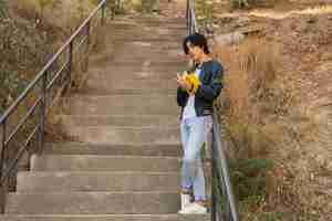 Free photo asian teenager standing with book on stairs