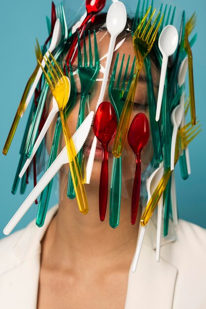 Азиатская женщина покрыта красочной пластиковой посудой