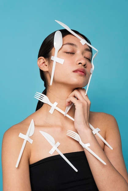 Asian woman being covered in white plastic tableware