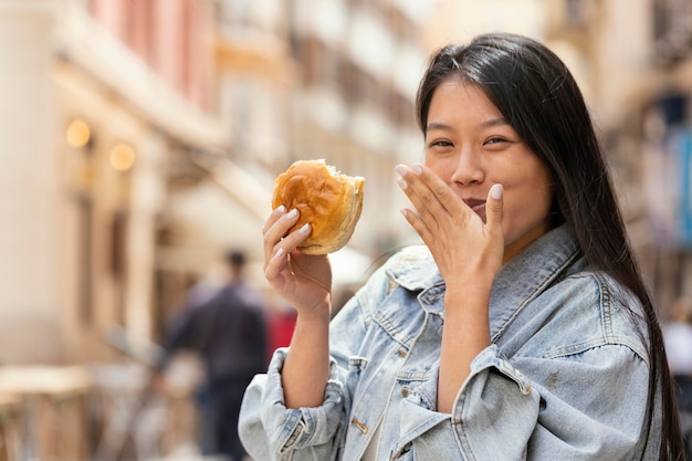 Foto gratuita donna asiatica che è felice dopo aver acquistato cibo di strada