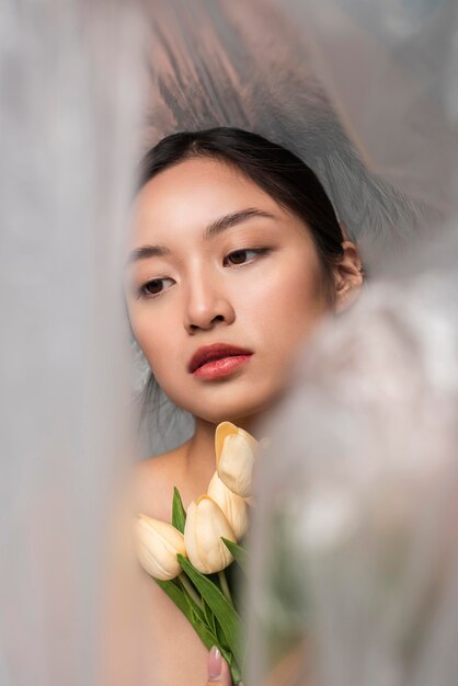 Asian woman covered in plastic holding a bouquet of flowers