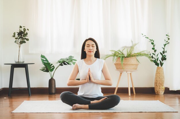 Asian woman doing yoga meditation at home