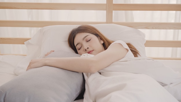 Asian woman dreaming while sleeping on bed in bedroom