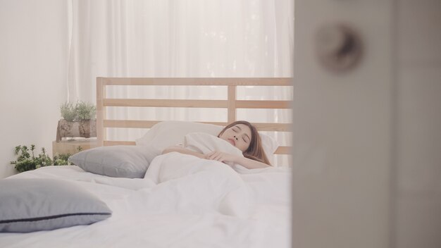 Asian woman dreaming while sleeping on bed in bedroom