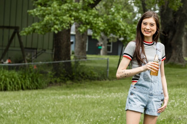 Asian woman drinking a beer in her garden